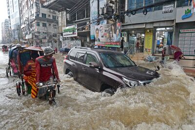 Commuters%20make%20their%20way%20through%20a%20water-logged%20street%20after%20a%20heavy%20downpour%20in%20Dhaka.%20Bangladesh%20is%20one%20of%20many%20countries%20struggling%20to%20protect%20residents%20from%20the%20effects%20of%20climate%20change.