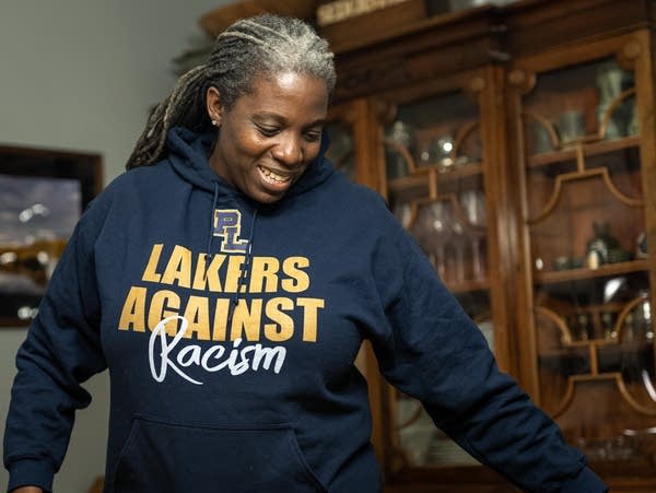 A Black woman wears a "Lakers Against Racism" hoodie