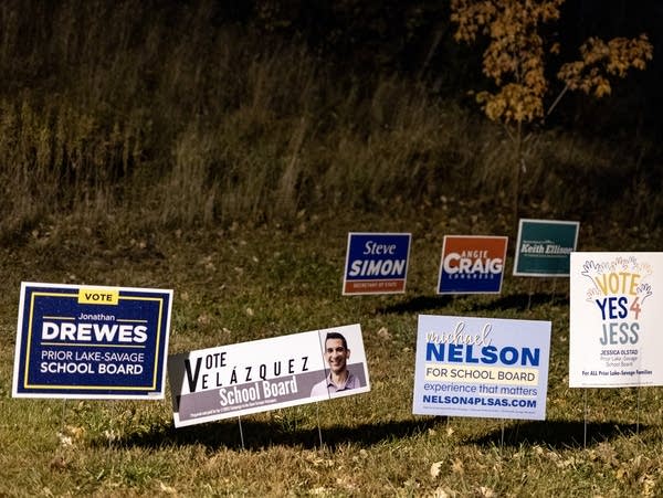 Seven lawn signs in a yard