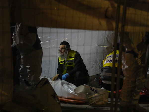 Members of Zaka Rescue and Recovery team check victims of a shooting attack that killed seven people and wounded three near a synagogue in Jerusalem on Friday.