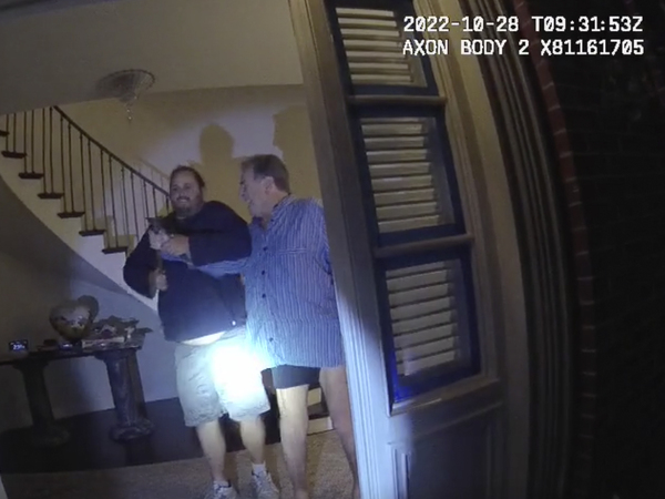 In this image taken from San Francisco Police Department body-camera video, Paul Pelosi (right) fights for control of a hammer with his assailant during a brutal attack on Oct. 28, 2022.