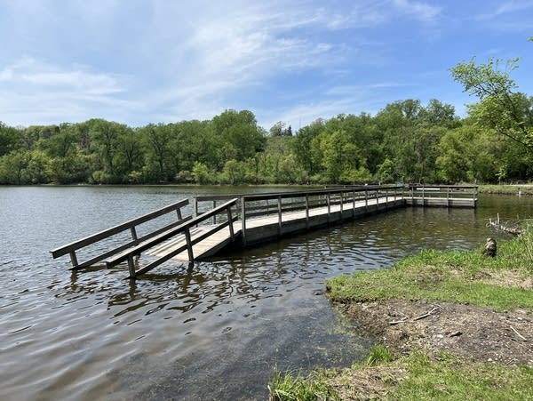 A fishing pier is seen dislodged from the shore of a lake