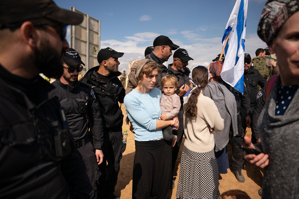 Israeli border police watch over protesters attempting to block the road at the Kerem Shalom border crossing, where Israel inspects trucks and allows them to cross into the Gaza Strip.