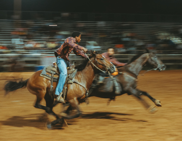 Riders pass a baton during a Pony Express relay race in Okmulgee, Okla.