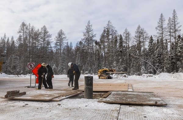 three people work on a drill site