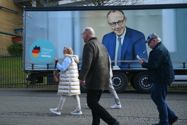 People walk past a truck with an election campaign poster featuring Friedrich Merz, leader of conservative Christian Democratic Union (CDU), in Oberhausen, Germany, on Feb. 21.