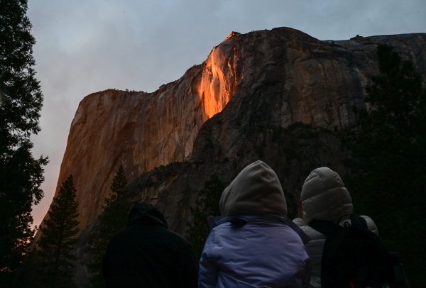 Visitors admire the "firefall effect" on El Capitan during sunset.