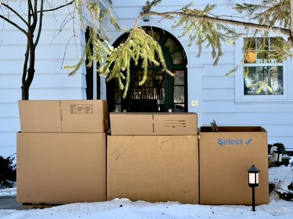 Boxes sit outside of a residence.