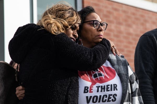 Two women hug.