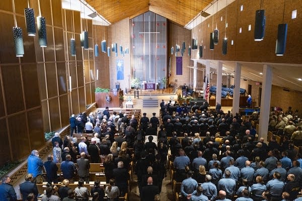 A casket is carried in a church