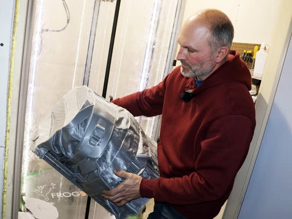 a man holds a sculpture