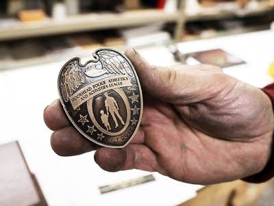 a man holds a replica police badge