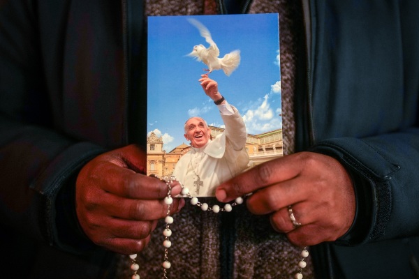 A priest holds a photograph of Pope Francis during the nightly rosary prayer service in St Peter's Square on Thursday, March 6 in Vatican City.