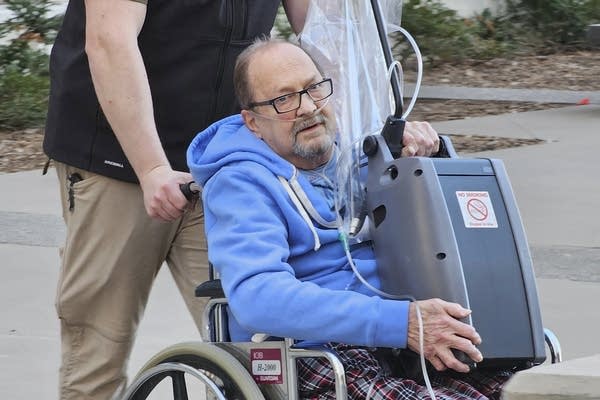 a man is wheeled out of a court