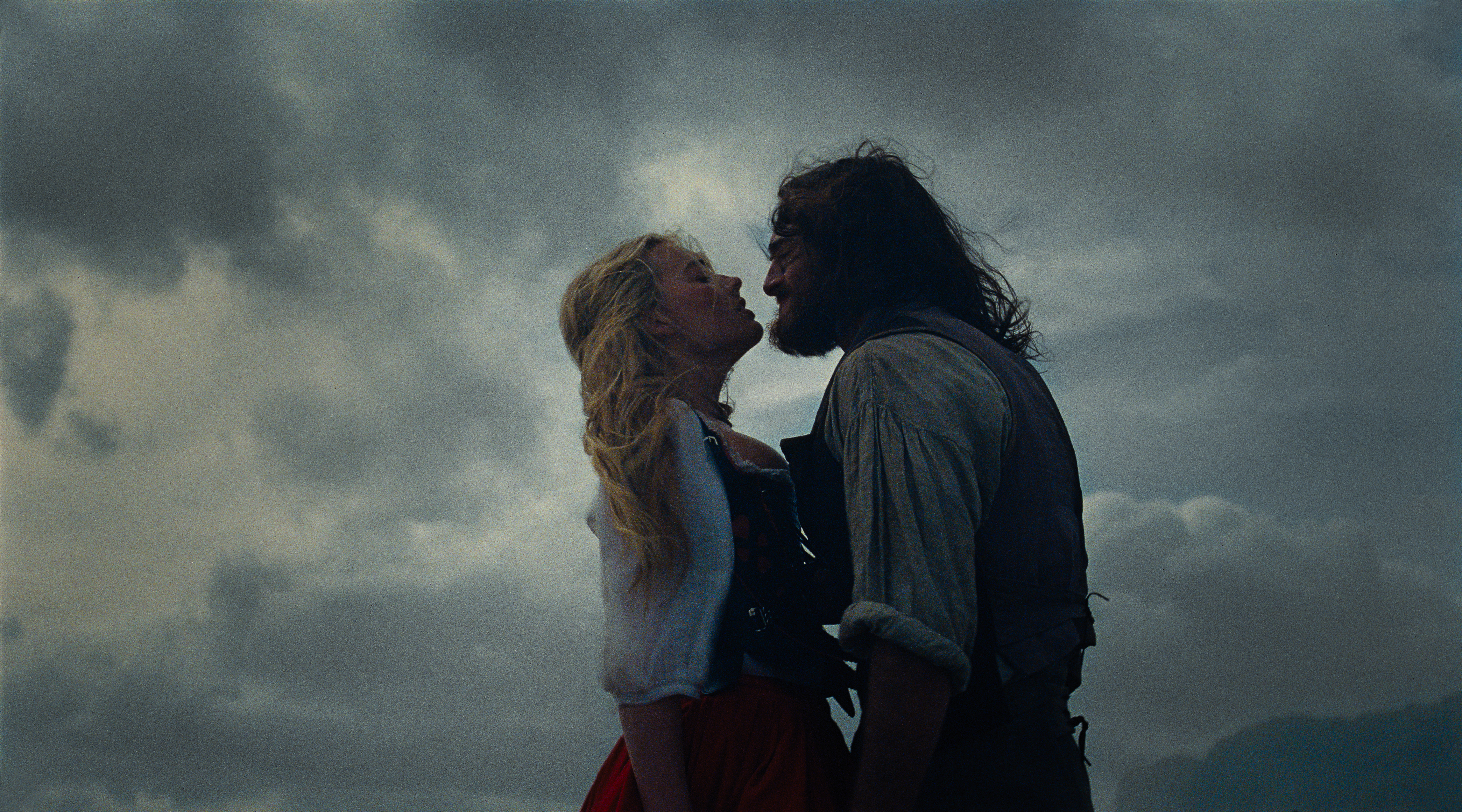 Robbie and Elordi as Catherine and Heathcliff, mid-clinch on the moors.