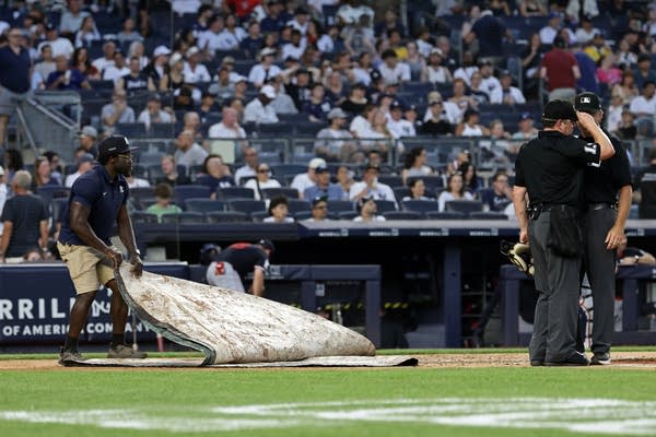 A member of the grounds crew covers the field