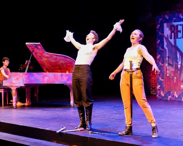 Two performers sing on stage.
