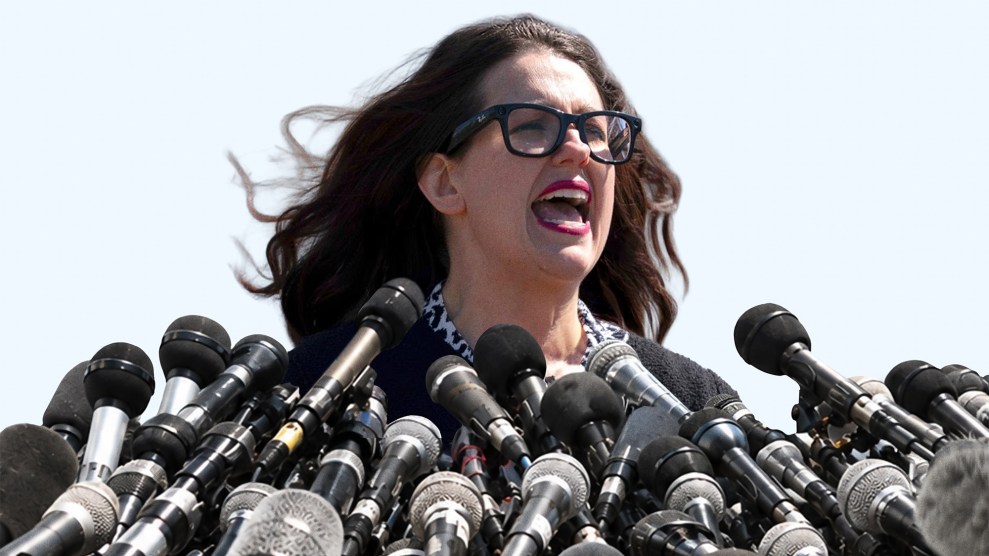 Kristan Hawkins speaks in front of an array of microphones.