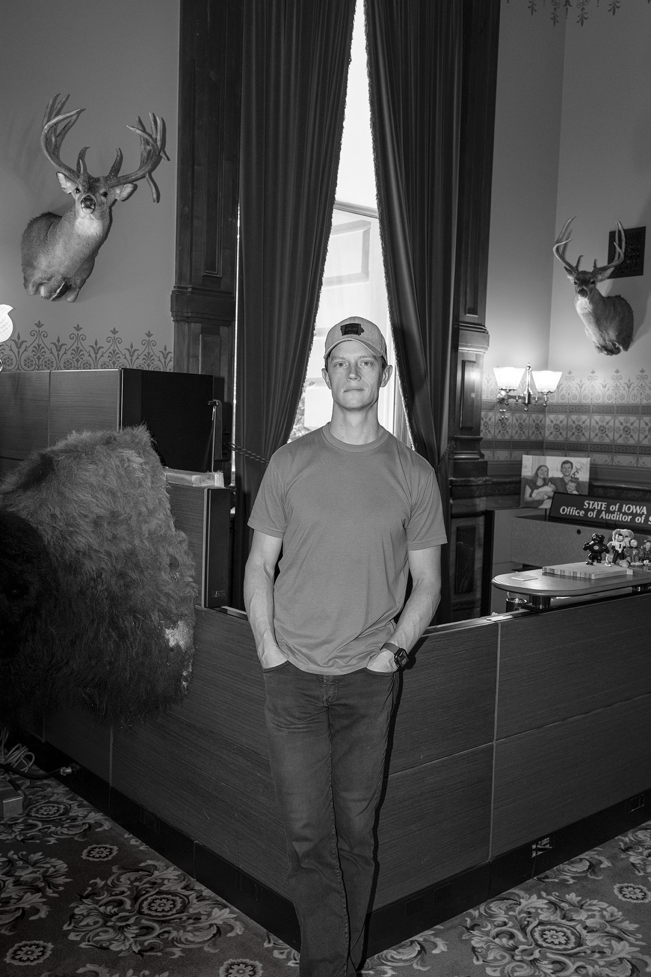 Rob Sand standing in an office with two deer heads on the wall.