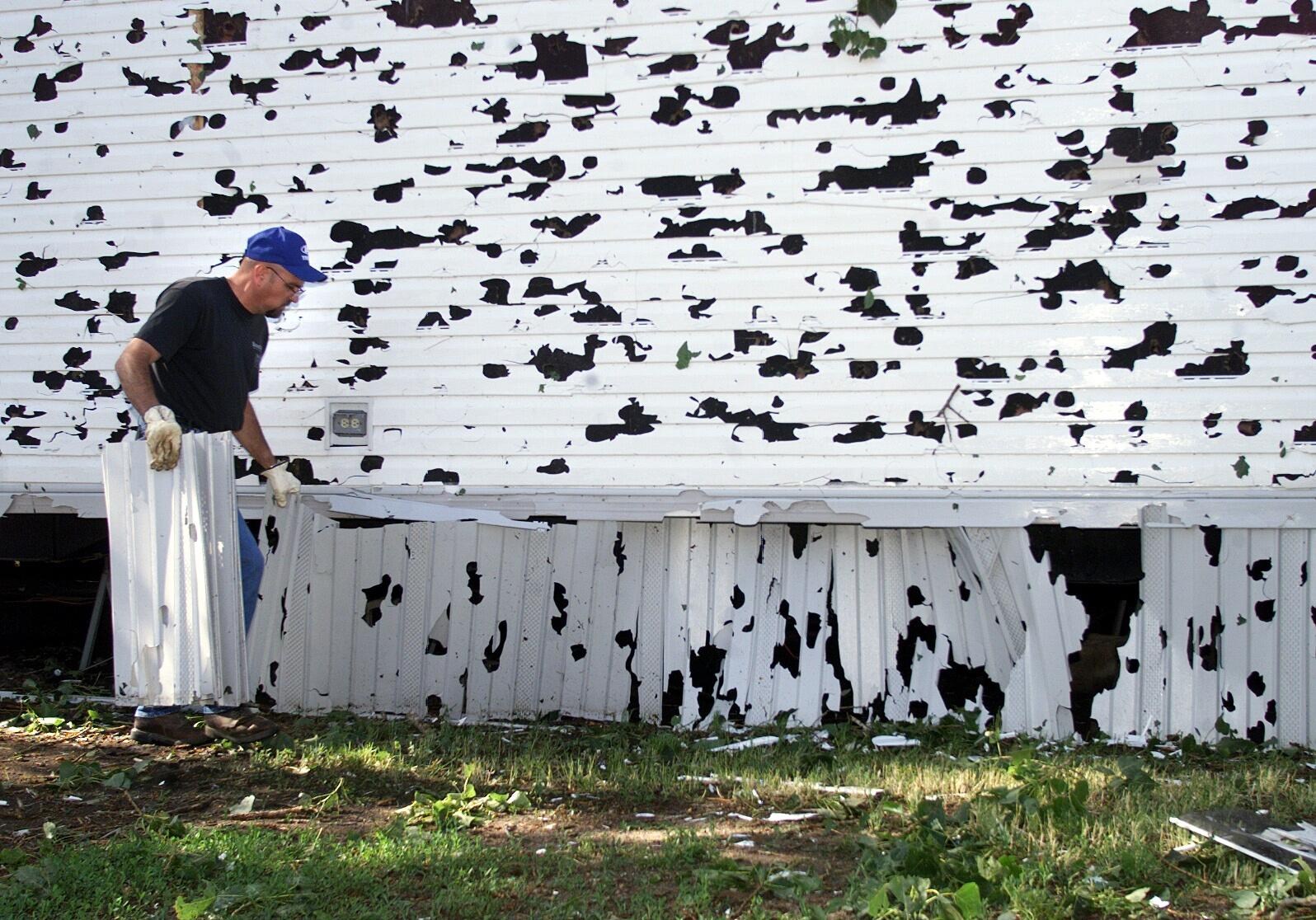 a person moves damaged vinyl sheets