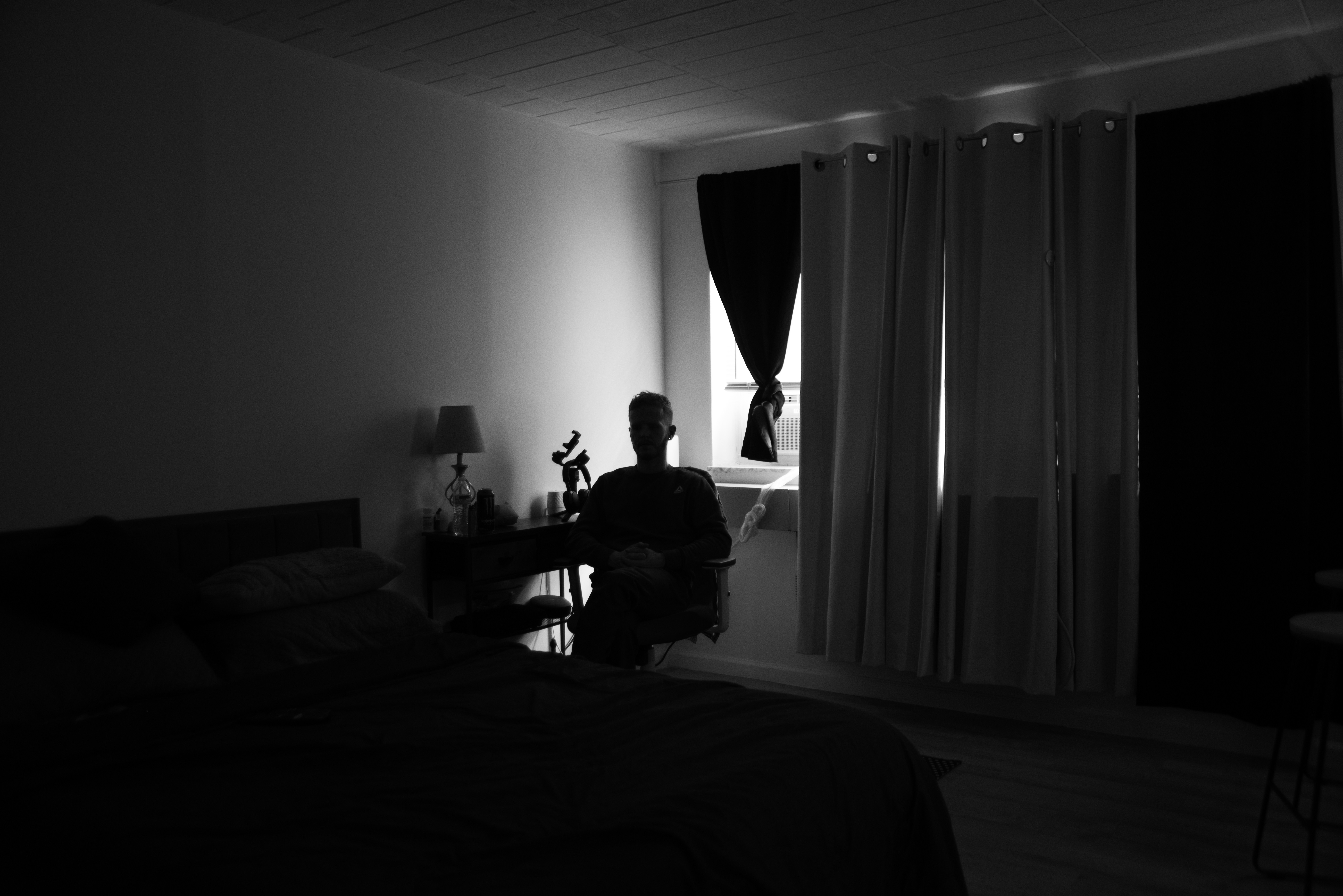 A person sits silhouetted near a window. 