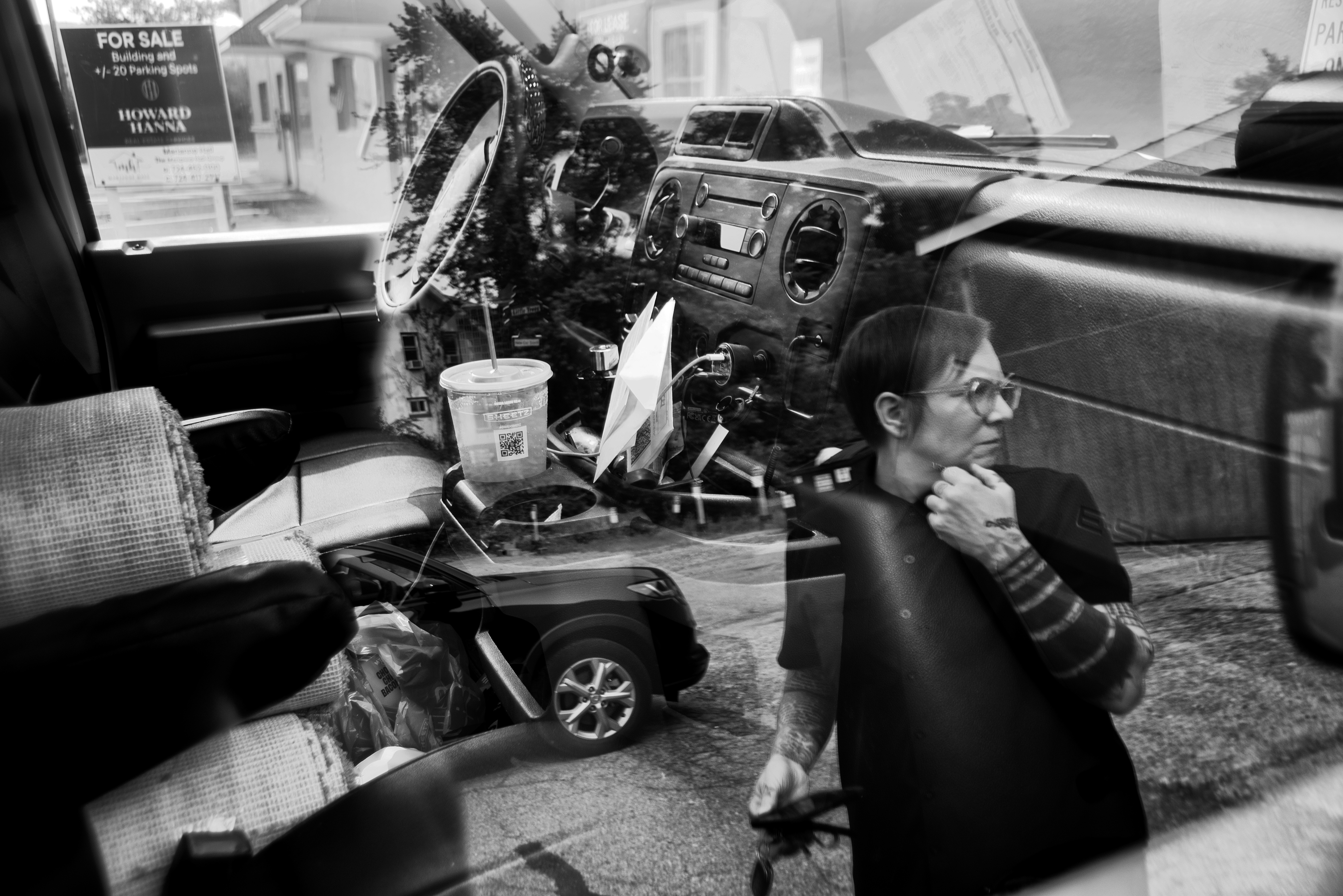 Reflection of woman seen through a car window.