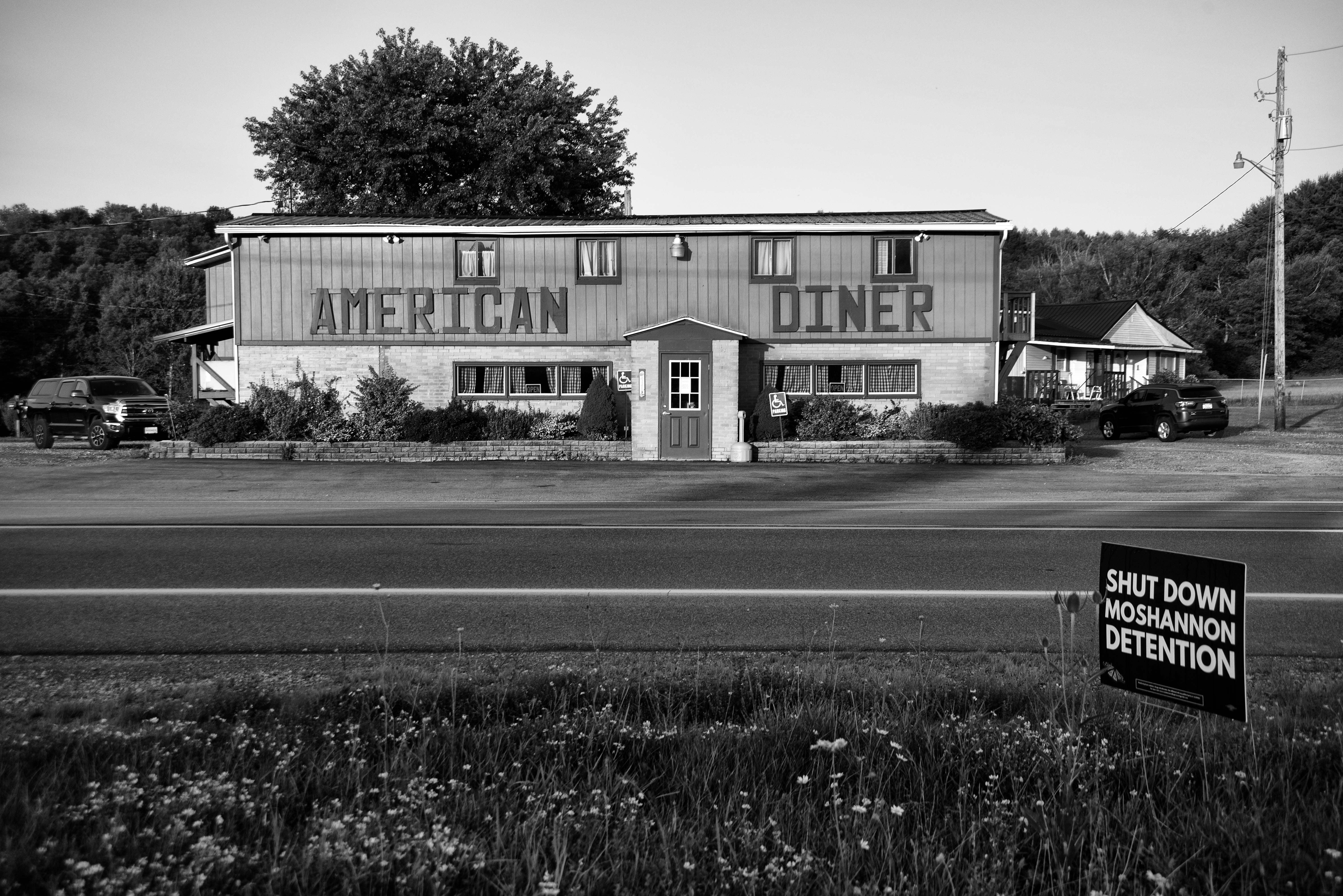 Diner with a sign across the street that reads "Shut down Moshannon Detention