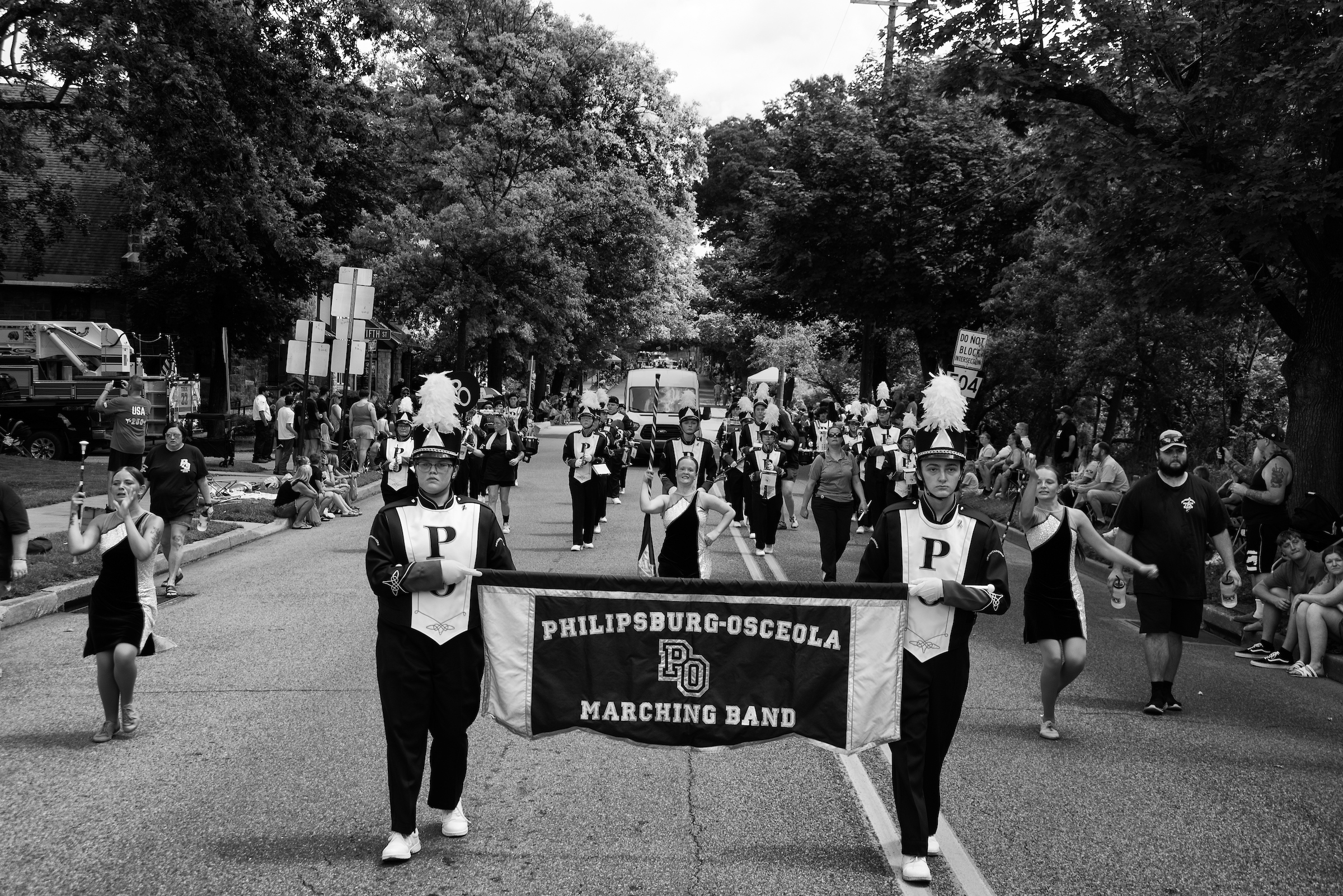 Marching band in a parade holding a banner that reads "Philipsburg-Osceola Marching Band."