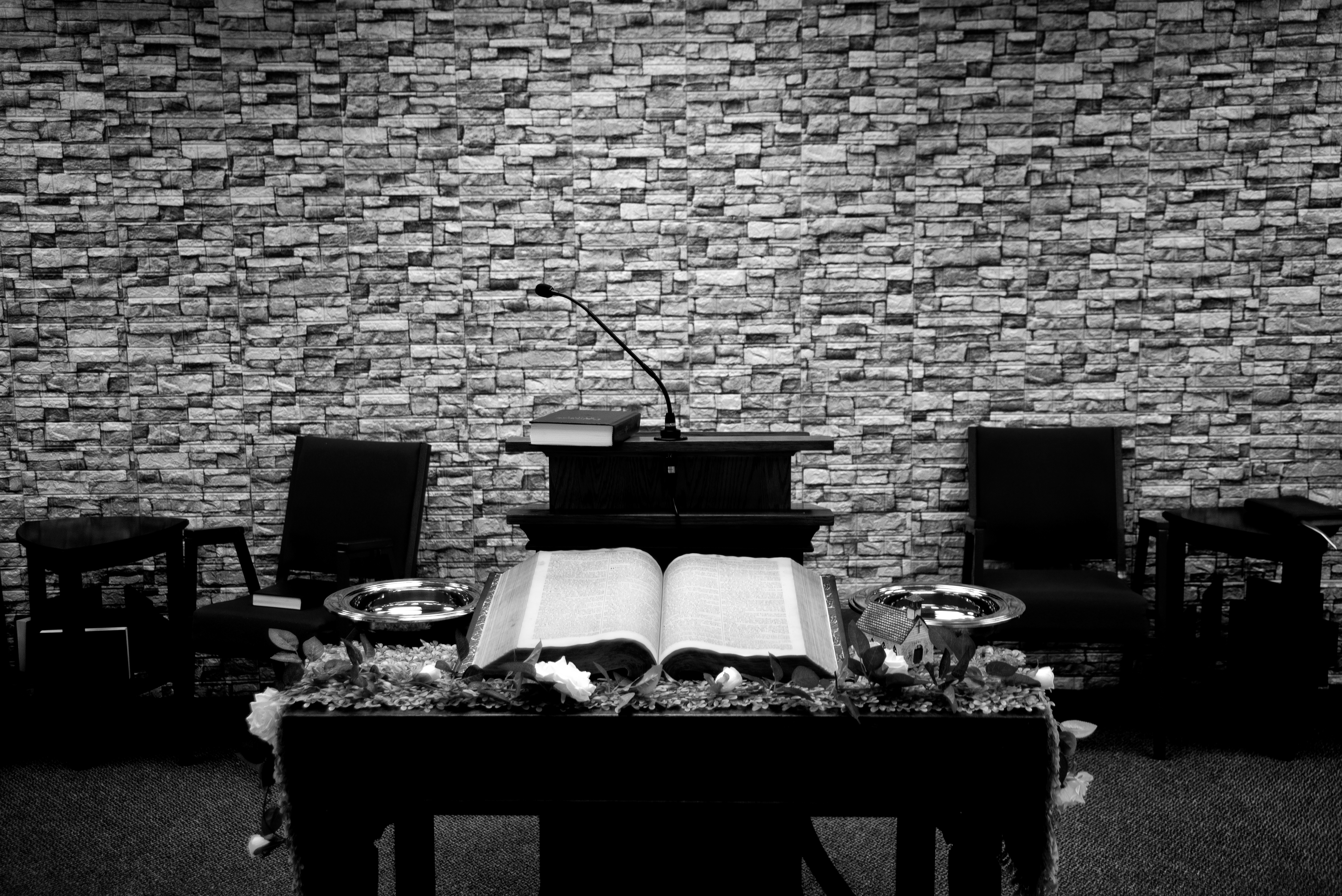 Large, open bible sitting on a table in front of a lecturn.