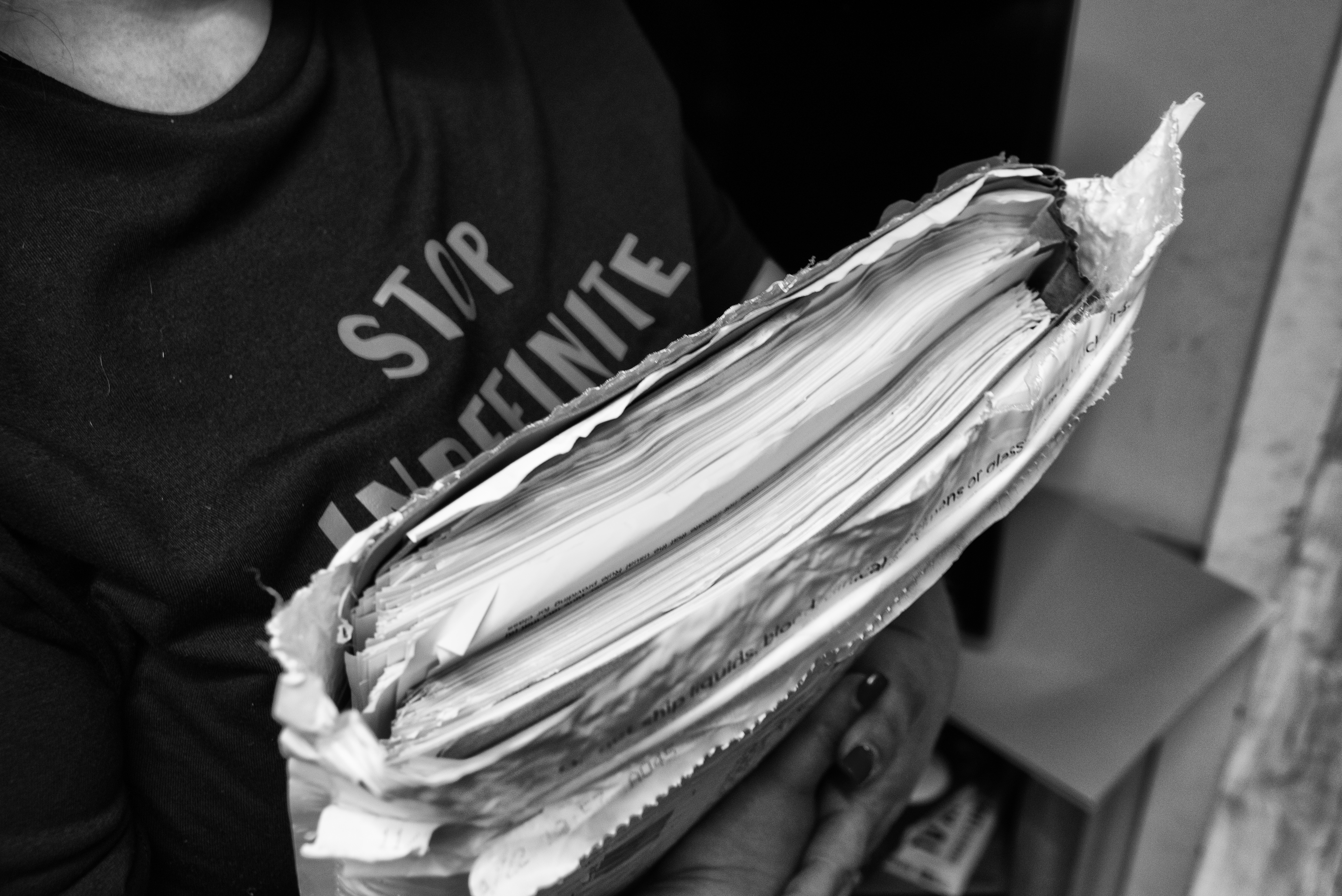 Close-up of a woman holding a large stack of documents.