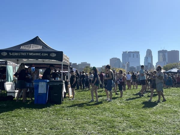 A brewery booth has people walking up to enjoy samples.