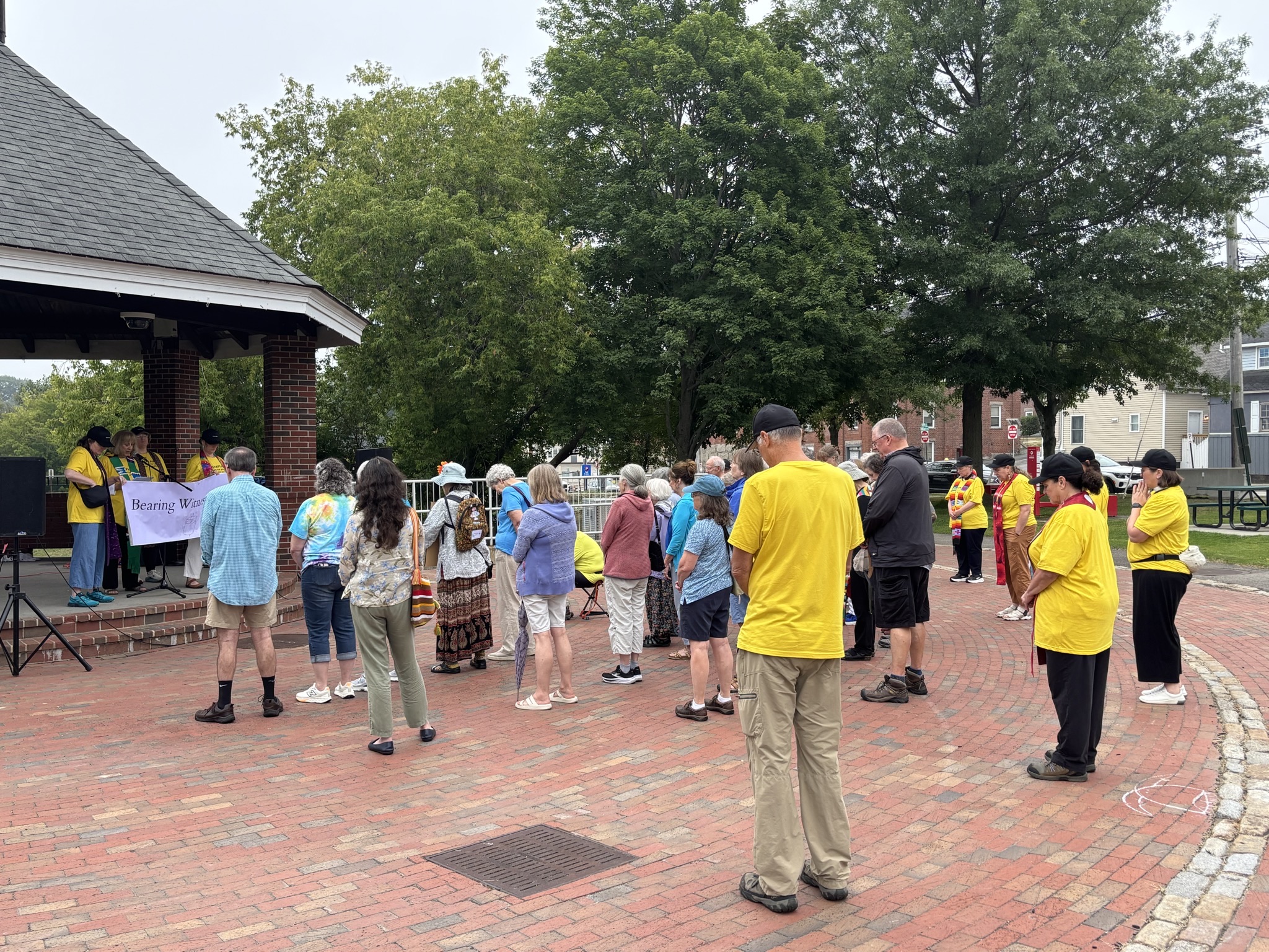 A group of people hold their head in prayer, as led by local religious leaders.