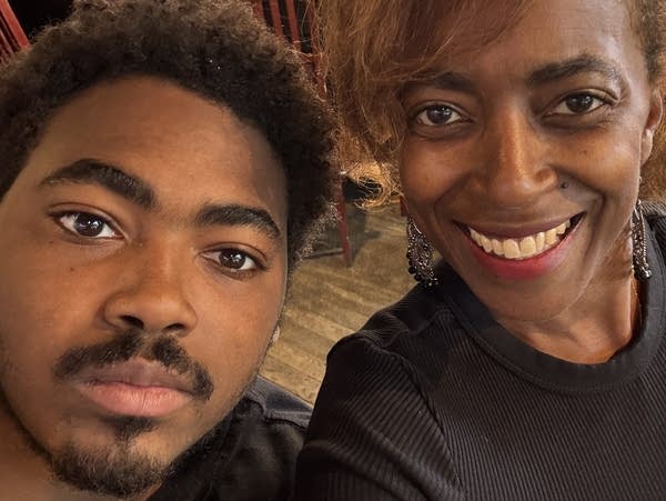 A young man poses for a selfie with his mother
