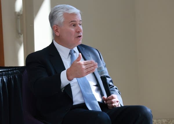 judge with gray hair and blue tie speaks at event