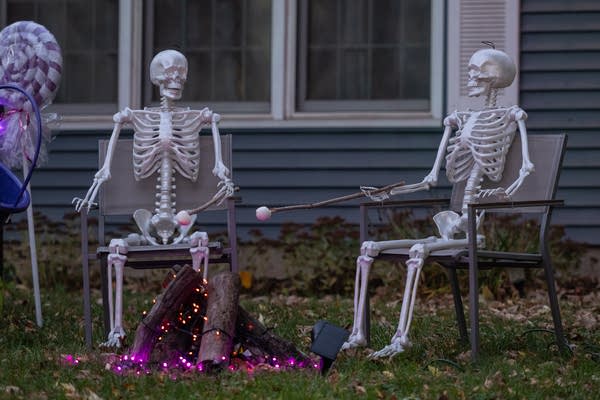 Skeletons roast marshmallows in a Halloween display