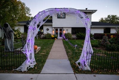 A spider web archway decorates a yard for Halloween