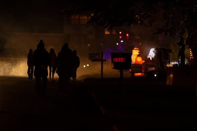 Crowds walk past houses with Halloween displays