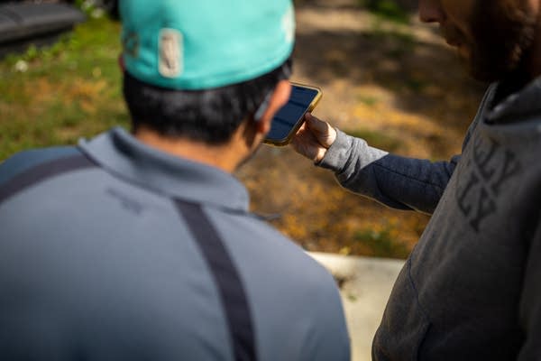 Two men talk using a phone app