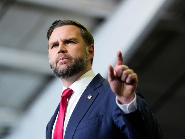 A man in a suit speaks at a political rally