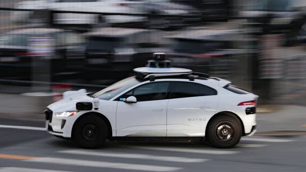 A Waymo autonomous vehicle navigates a city street
