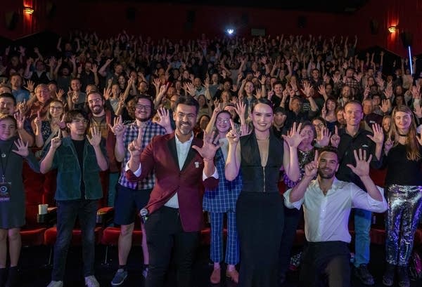 a crowd stands in a theater