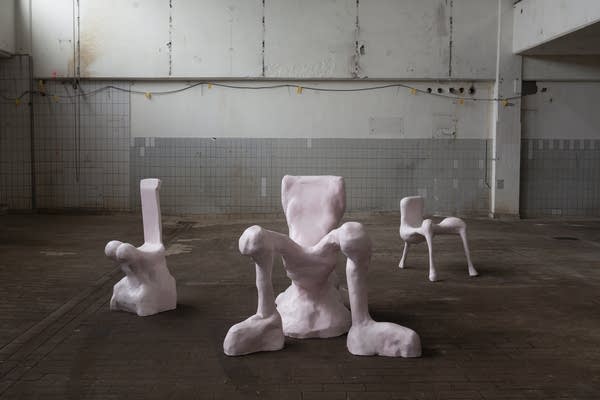 sculptures that resemble chairs in an empty room
