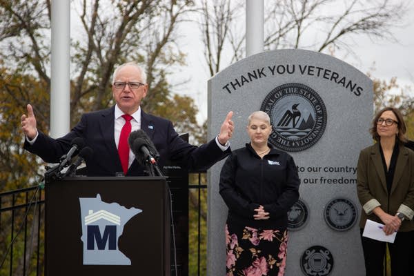 Tim Walz speaking outside at a presser