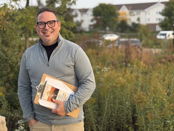 Simon Glaser poses for photo holding a clipboard