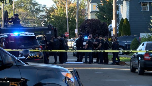 Police gather outside of a scene of a shooting