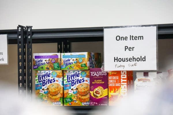 Boxes of snacks sit on a shelf with the sign, 
