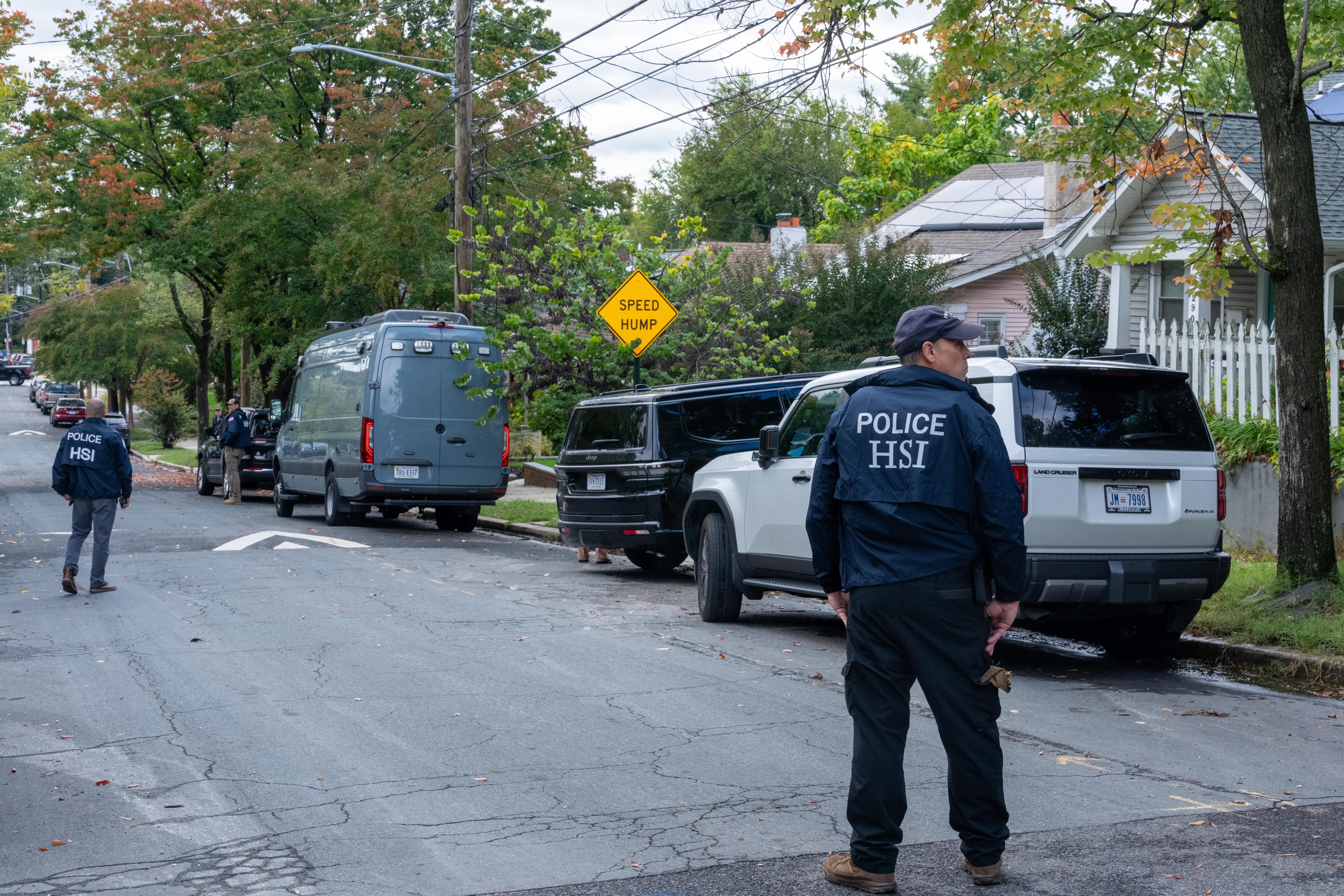 Men wearing homeland security jacket standing in the middle of a neighborhood street